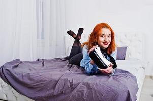 roodharige meisje in bed met vr-bril op studio kamer. foto