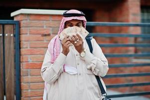 Midden-Oosten Arabische zakenman poseerde op straat tegen modern gebouw met zwarte handtas en eurogeld. foto