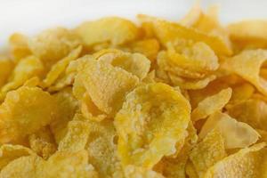 afbeelding close-up cornflakes granen ontbijt in witte kom op houten tafel. foto