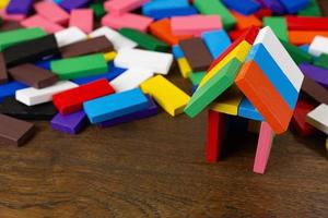 de domino veelkleurige huis bouwen op houten tafel afbeelding. foto