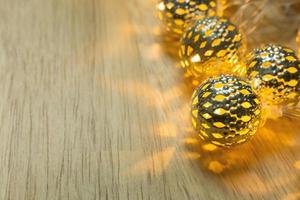 kerst gouden lichten bal decor op houten tafel. foto