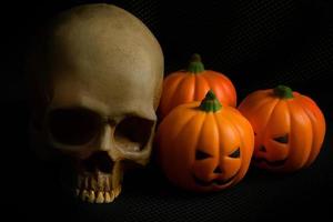 de halloween pompoen jack en schedel in zwarte vakantie achtergrondafbeelding. foto