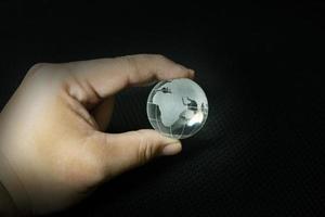 de glazen bol planeet aarde en hand afbeelding. foto