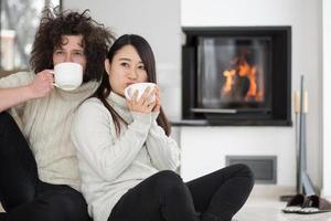 gelukkig multi-etnisch paar voor open haard foto