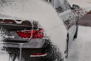 auto schoonmaken met zeep en waterdruk. auto wassen. vervoer gewassen bij lokale wasstraat. voertuigconcept. wasservice foto