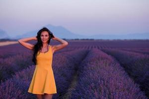vrouw in gele jurk bij lavendelveld foto
