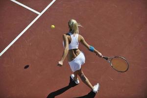 jonge vrouw speelt tennis foto