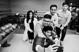 groep van vijf Zuid-Aziatische volkeren die rust en plezier hebben bij de bowlingclub. selfie maken via de telefoon. foto