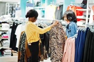 twee afrikaanse vrouw die kleding kiest in de winkel. shop dag. foto