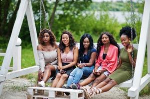 groep van vijf Afro-Amerikaanse meisjes ontspannen op mooie schommel. foto