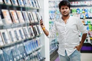 indiase man klant koper bij mobiele telefoon winkel kiest zijn nieuwe smartphone. Zuid-Aziatische volkeren en technologieën concept. gsm winkel. foto