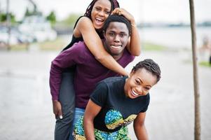 drie Afro-Amerikaanse vrienden die samen plezier hebben. op schouder springen. foto