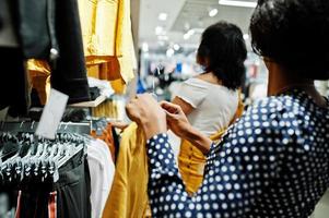 twee afrikaanse vrouw die kleding kiest in de winkel. shop dag. foto