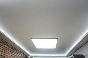 halogeenspots lampen op verlaagd plafond en gipsplaten constructie in in lege ruimte in appartement of huis. spanplafond wit en complexe vorm. foto