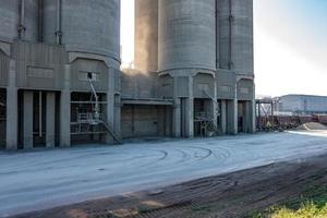 industrieel grijs landschap milieuvervuiling afval van cementfabriek. grote pijpen van industriële ondernemingsfabriek. bergen van zand en puin foto