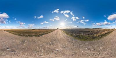 volledig naadloos bolvormig hdri-panorama 360 graden hoekzicht op onverharde weg tussen velden in de lente met geweldige wolken in equirectangular projectie, klaar voor vr ar virtual reality-inhoud foto
