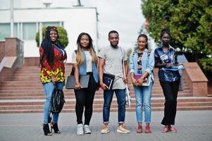 groep van vijf afrikaanse studenten die samen tijd doorbrengen op de campus op de universiteitswerf. zwarte afro-vrienden studeren. onderwijs thema. foto