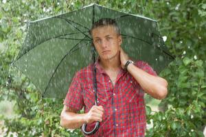 man met paraplu in de regen foto