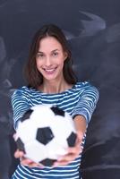 vrouw die een voetbal voor krijttekenbord houdt foto