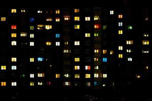 plat nachtpanorama van veelkleurig licht in ramen van gebouwen met meerdere verdiepingen. leven in de grote stad foto