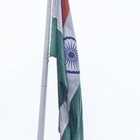 indiase vlag hoog op connaught plaats met trots in blauwe lucht, indiase vlag wapperen, indiase vlag op onafhankelijkheidsdag en republiek dag van india, tilt-up shot, wuivende indische vlag, har ghar tiranga foto