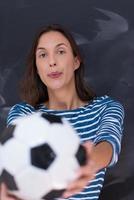 vrouw die een voetbal voor krijttekenbord houdt foto