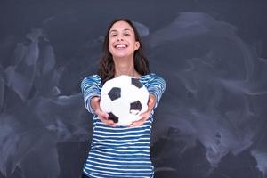 vrouw die een voetbal voor krijttekenbord houdt foto