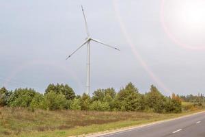 roterende bladen van een windmolenpropeller op blauwe hemelachtergrond. opwekking van windenergie. pure groene energie. foto