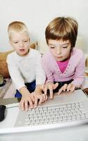 kinderen hebben plezier en spelen spelletjes op een laptopcomputer foto