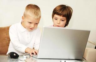 kinderen hebben plezier en spelen spelletjes op een laptopcomputer foto