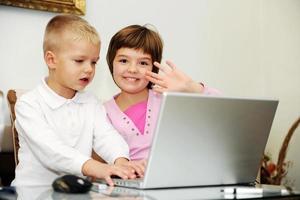 kinderen hebben plezier en spelen spelletjes op een laptopcomputer foto