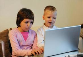 kinderen hebben plezier en spelen spelletjes op een laptopcomputer foto