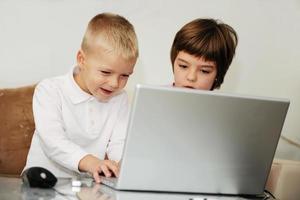 kinderen hebben plezier en spelen spelletjes op een laptopcomputer foto