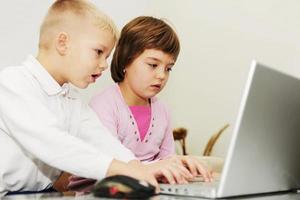 kinderen hebben plezier en spelen spelletjes op een laptopcomputer foto