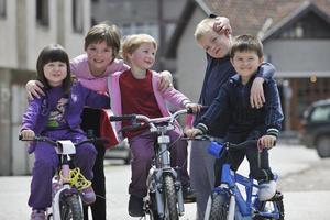 gelukkige kindergroep leren fietsen