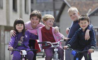 gelukkige kindergroep leren fietsen foto