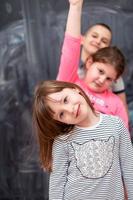 groep kinderen die voor schoolbord staan foto