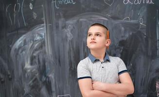 portret van kleine jongen voor schoolbord foto