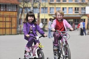 gelukkige kindergroep leren fietsen foto