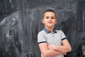 portret van kleine jongen voor schoolbord foto