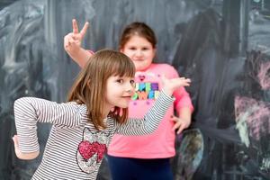 kleine meisjes die plezier hebben voor schoolbord foto