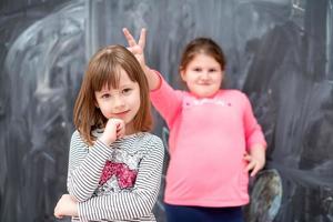 kleine meisjes die plezier hebben voor schoolbord foto