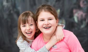 kleine meisjes knuffelen voor schoolbord foto