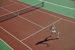 jonge vrouw speelt tennis foto