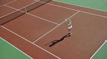 jonge vrouw tennissen buiten foto