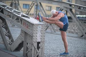 knappe man die zich uitstrekt voordat u jogt foto