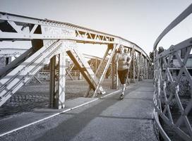 vrouw joggen over de brug op zonnige ochtend foto