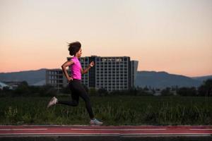 een jonge Afro-Amerikaanse vrouw die buiten jogt foto