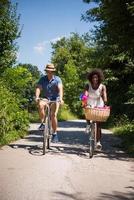 jong multi-etnisch koppel met een fietstocht in de natuur foto