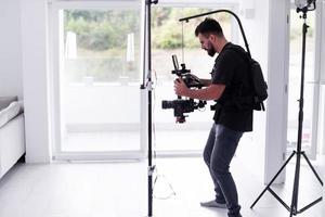 professionele videograaf met gimball video slr die thuis video opneemt foto